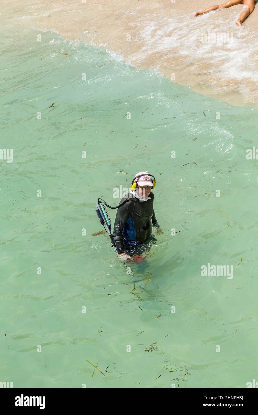 Der Mensch sucht mit einem Metalldetektor nach Tressys im Ozean Stockfoto