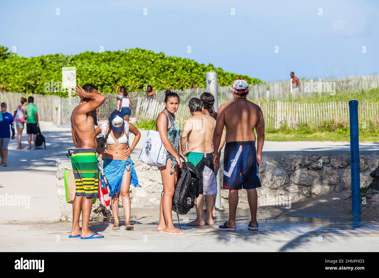 Die Leute warten am Strand des Ozeans auf eine Dusche Stockfoto