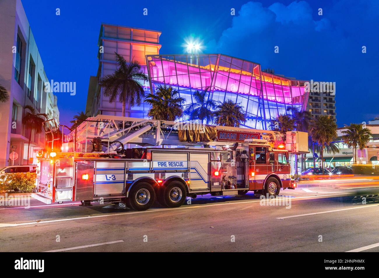 Feuerwehrauto bei Nacht vor einem neuen Art-Deco-Gebäude mit Neonlicht in South Beach, Miami Beach Stockfoto