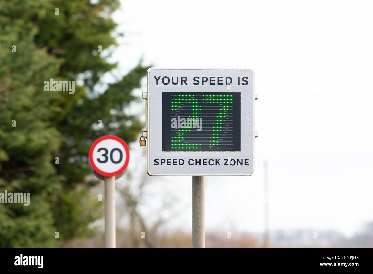 Geschwindigkeitsanzeige -Fahrzeug aktiviert Geschwindigkeitsschild zeigt Fahrer bewegt sich innerhalb der Geschwindigkeitsbegrenzung bei 27mph in 30mph Bereich in Dorf, England Großbritannien Stockfoto