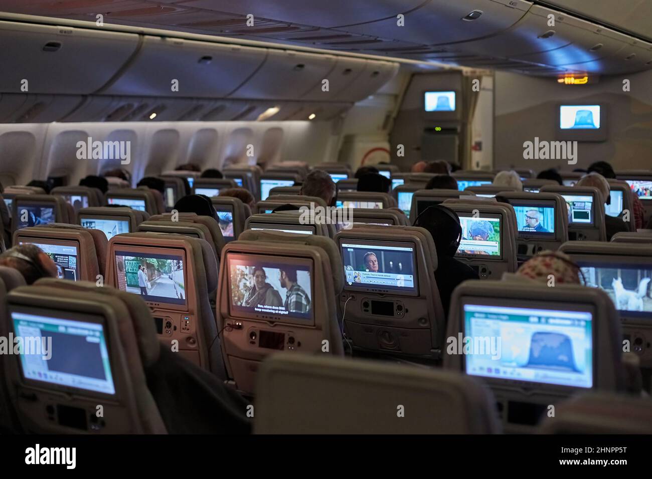 Innenraum der Flugzeugkabine, Passagiere schauen sich Filme an Stockfoto