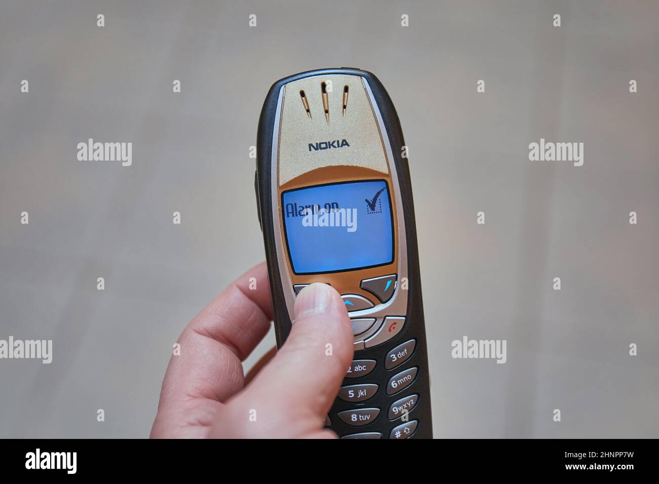 Einstellen des Alarms auf einem alten Mobiltelefon, dem Nokia 6310i Stockfoto