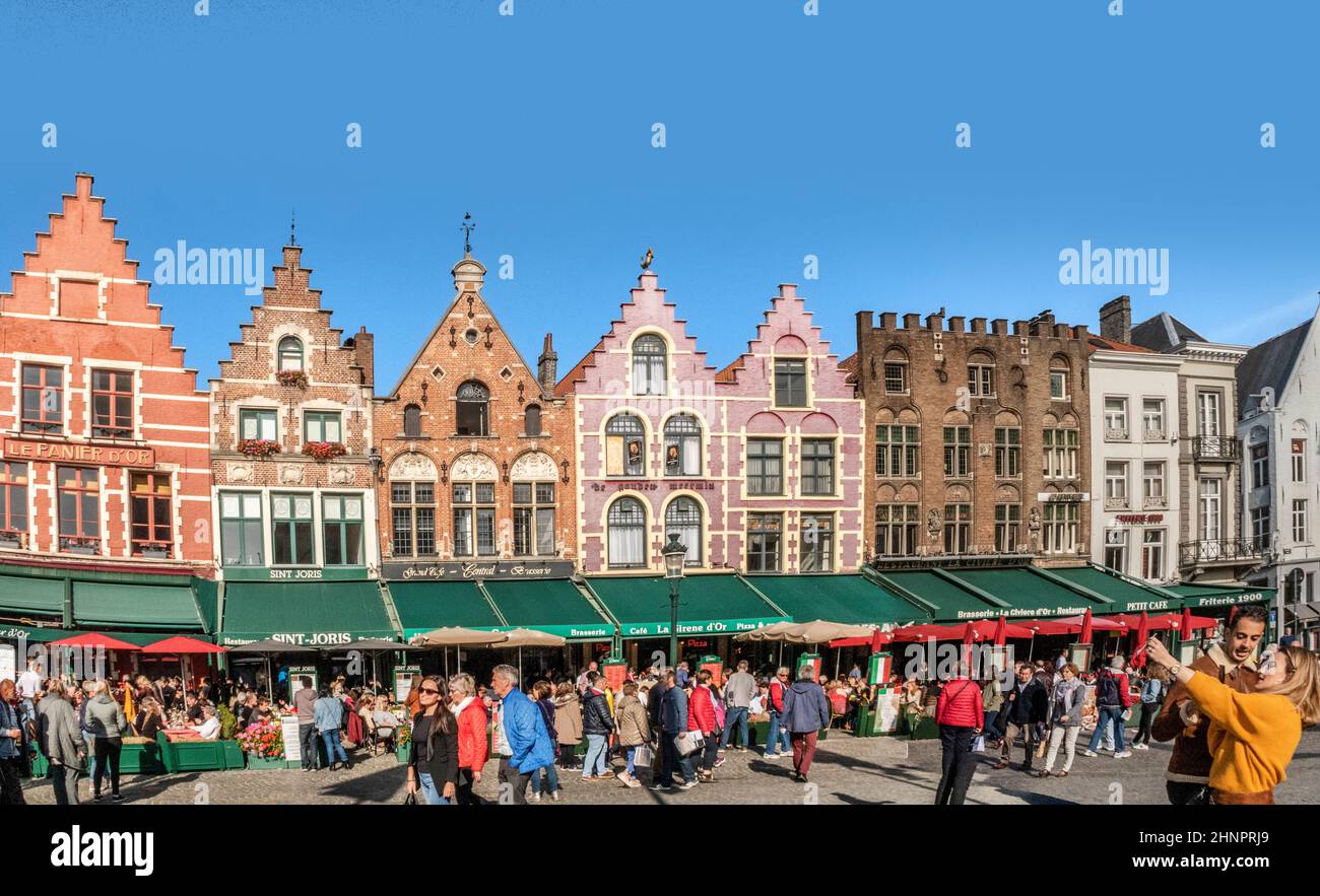 Touristen genießen einen schönen sonnigen Tag und machen Fotos auf dem Marktplatz (Markt) in Brügge. Stockfoto