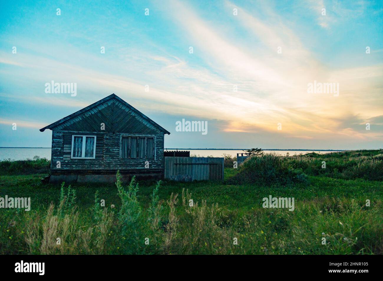 Altes Holzhaus am Meer. Wunderbare Landschaft mit einem wunderschönen Sonnenuntergang Stockfoto