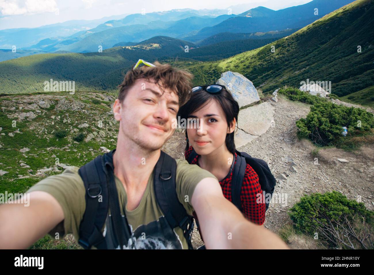 Luftaufnahme des Great Green Ridge. Guy und Girl stehen auf einem großen Hügel vor dem Hintergrund einer riesigen Berglandschaft Stockfoto