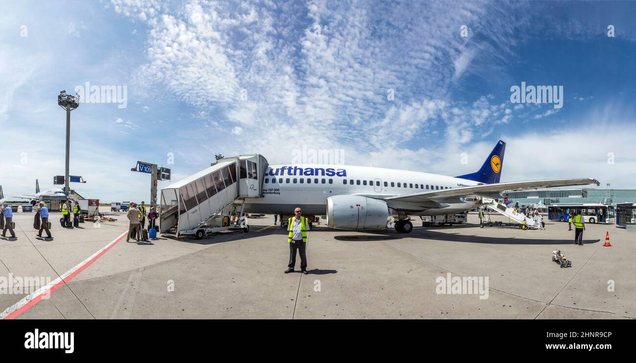 Menschen besteigen den Lufthansa-Flug mit Position am Vorfeld, da es am Terminal zu wenig Gates gibt. Stockfoto