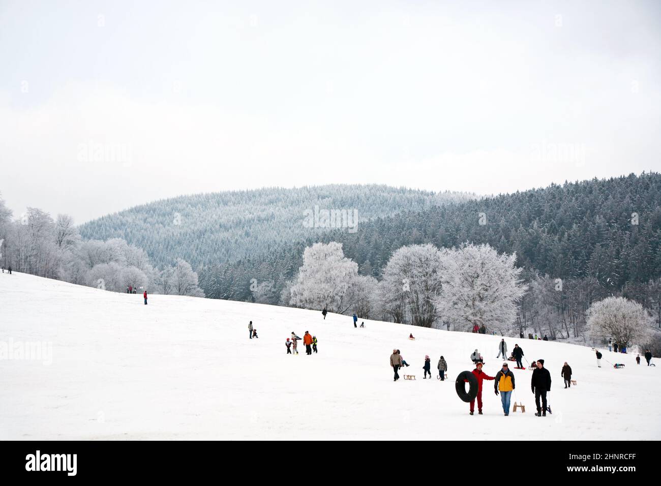 Kinder sind Skaten in eine Rodelbahn im Winter auf Schnee Stockfoto