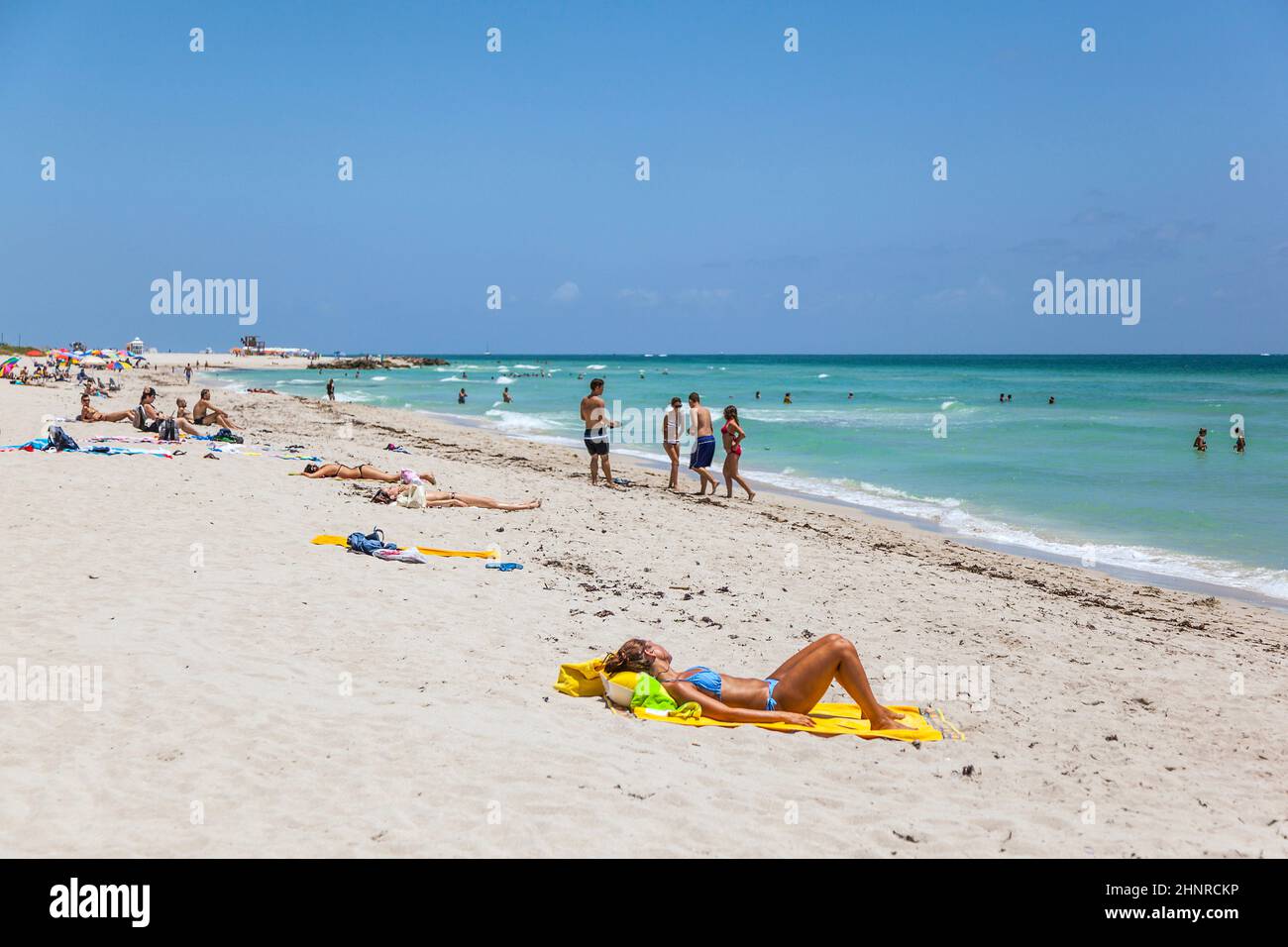 Touristen sonnen sich, schwimmen und spielen auf South Beach in Miami Beach, Florida Stockfoto