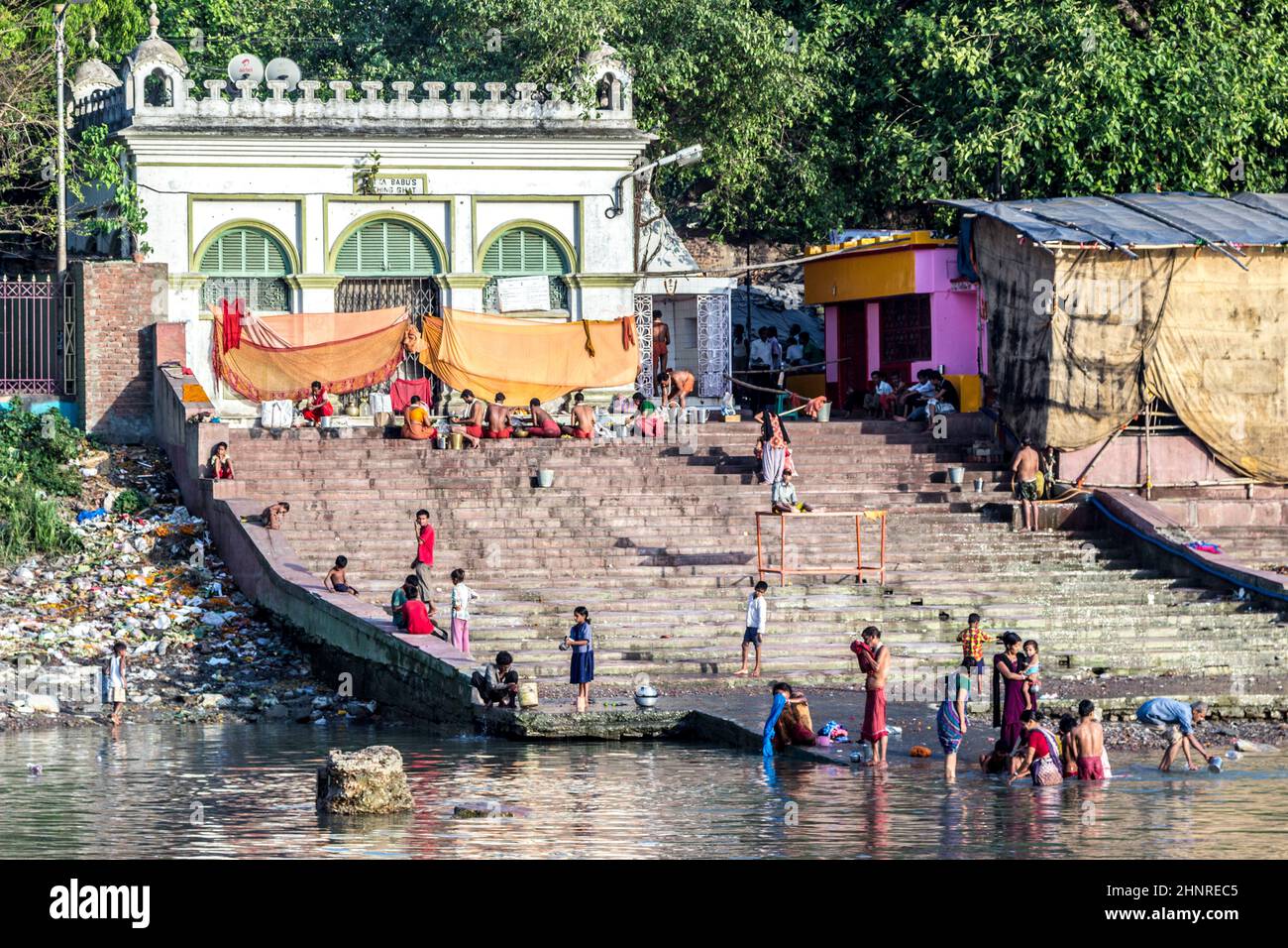 Menschen, die im Fluss Ganges in Kalkutta Kleidung putzen und waschen Stockfoto Menschen, die im Fluss Ganges in Kalkutta Kleidung putzen und waschen Stockfoto
