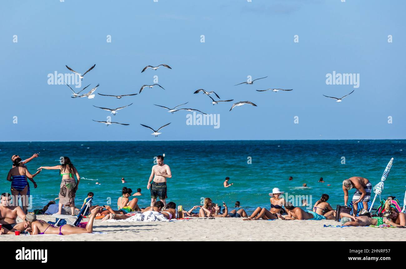 Strandszene am Ende des Tages. Die Menschen genießen immer noch die Nachmittagssonne. Stockfoto