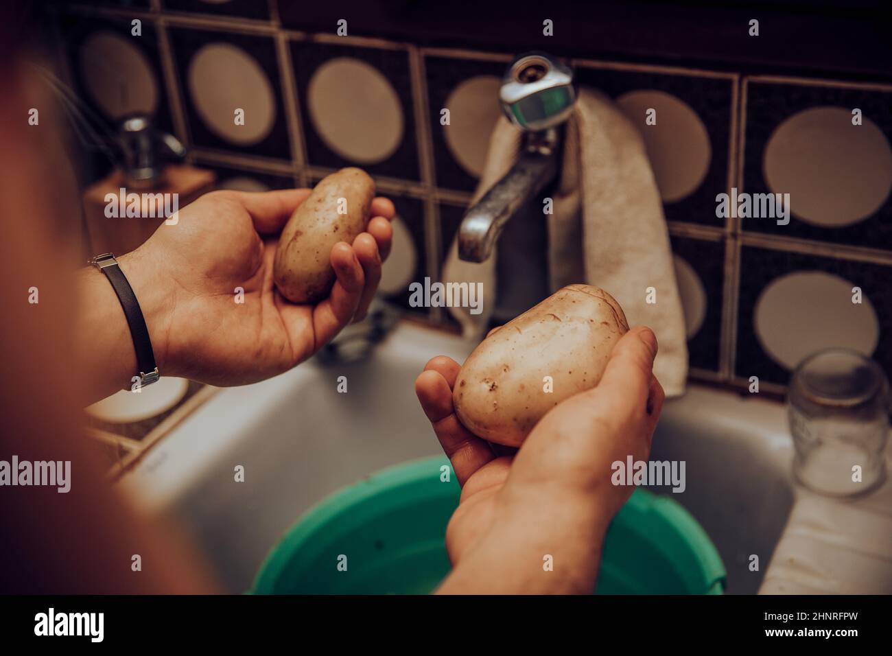 Hände waschen Kartoffeln im Waschbecken Stockfoto