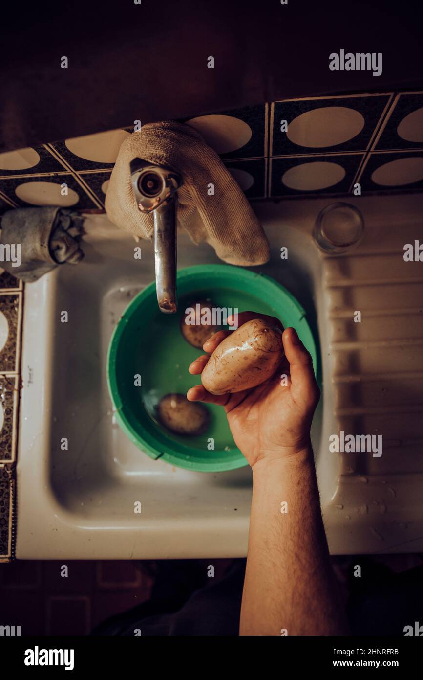Hände von oben waschen Kartoffeln in der Spüle Stockfoto