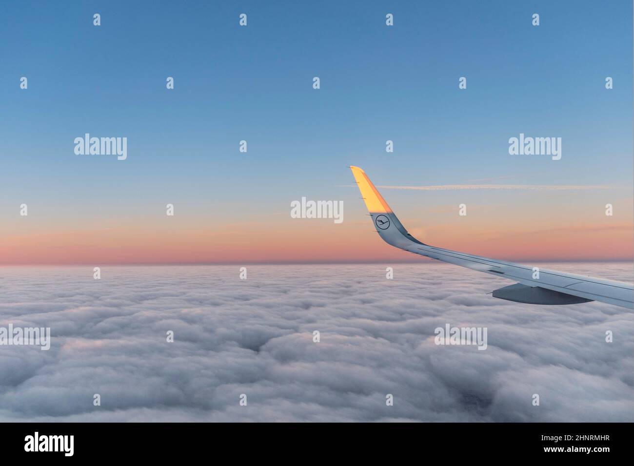 Sonne am Flügel eines Flugzeugs, das bei Sonnenaufgang fliegt Stockfoto
