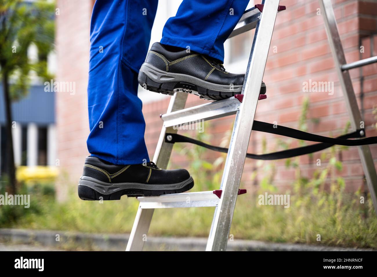 Mann Kletternde Trittleiter In Sicherheitsschuhen Stockfoto