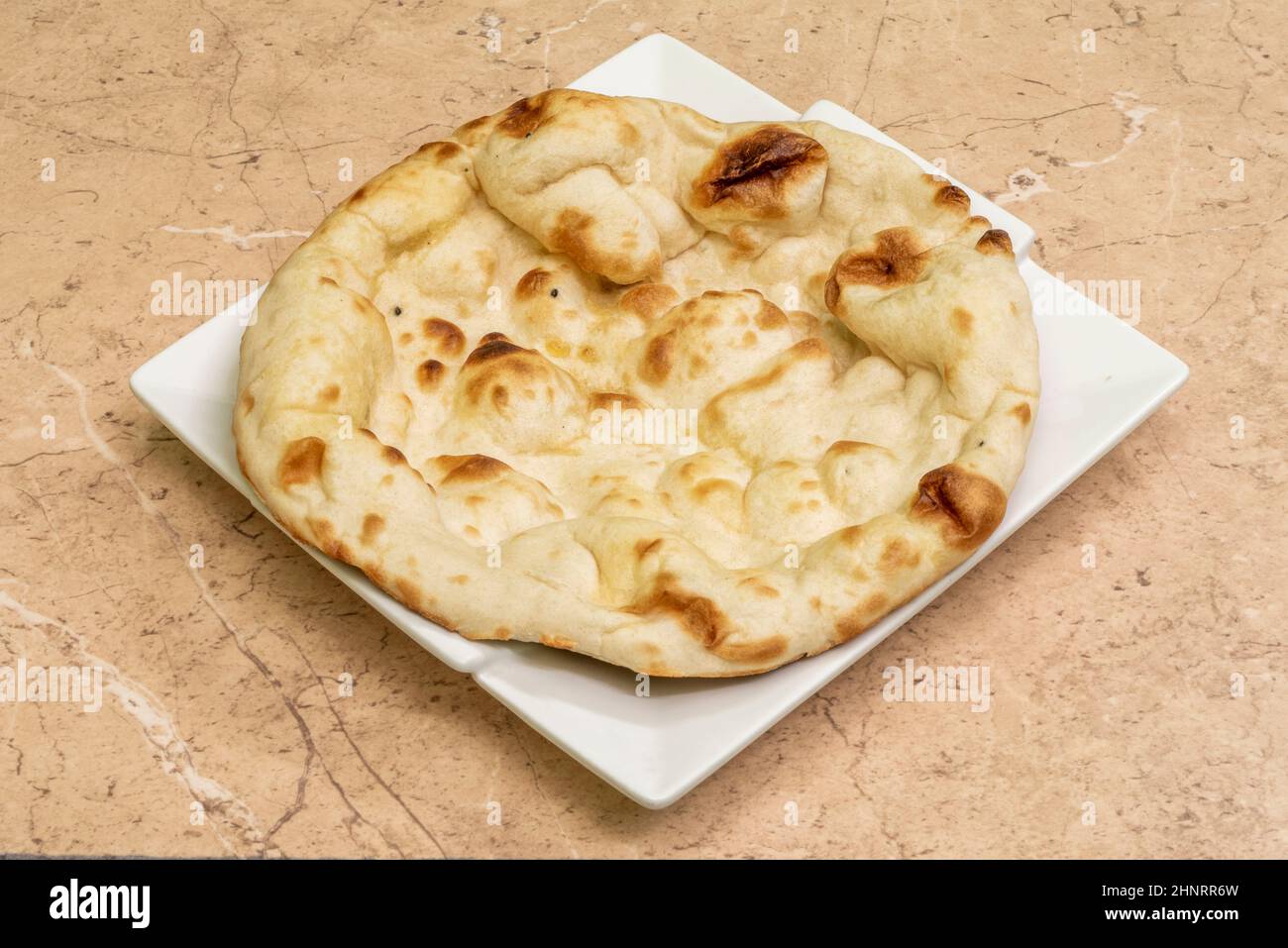 Naan ist ein Fladenbrot, das aus Weizenmehl hergestellt und in der Regel gesäuert wird. Es wird häufig in verschiedenen Regionen Zentralasiens und Südasiens konsumiert. Stockfoto