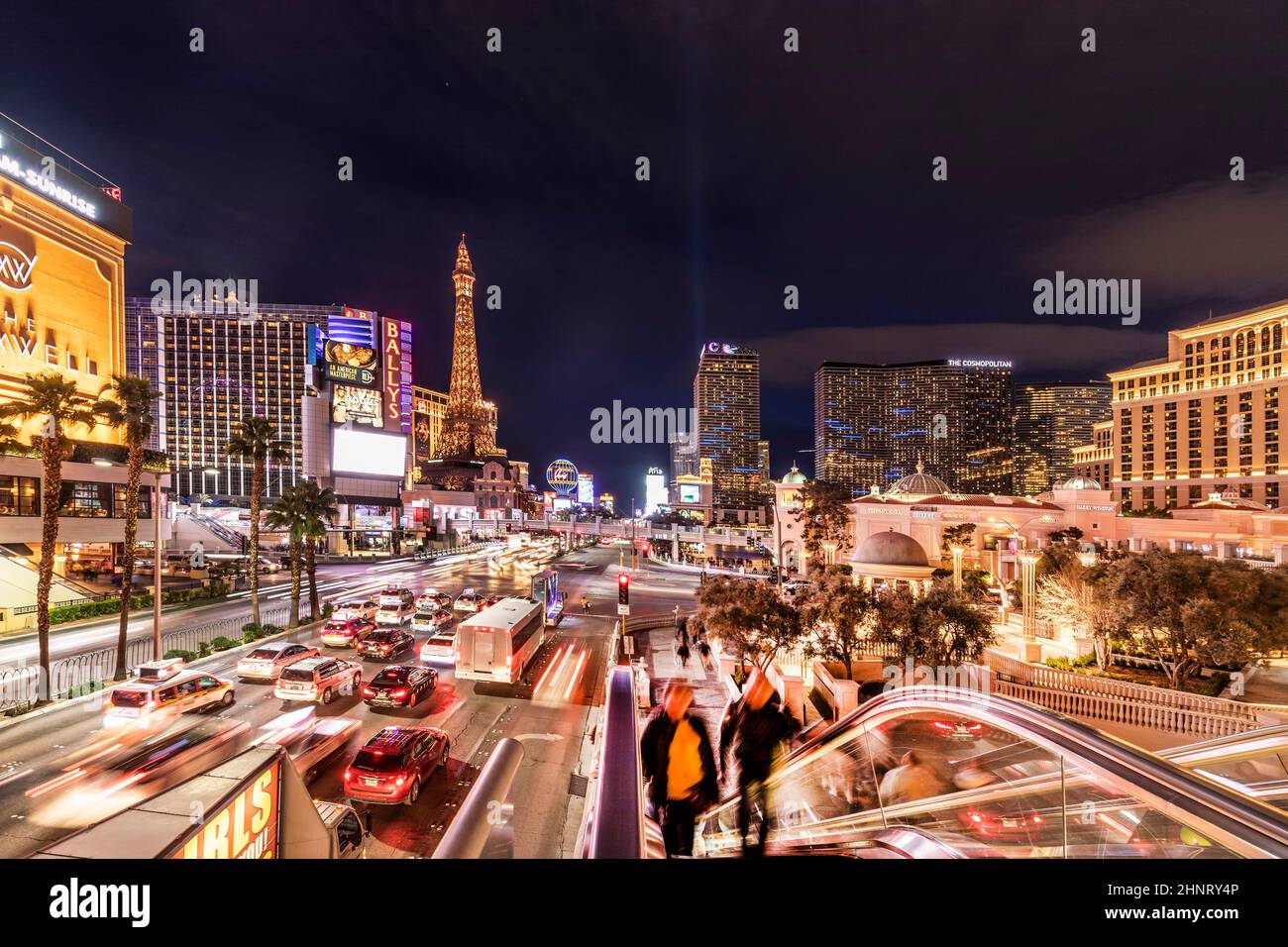 Autos bei Nacht auf dem Strip in Las Vegas und Casinos bei Nacht mit Leuten, die den Bürgersteig entlang laufen Stockfoto