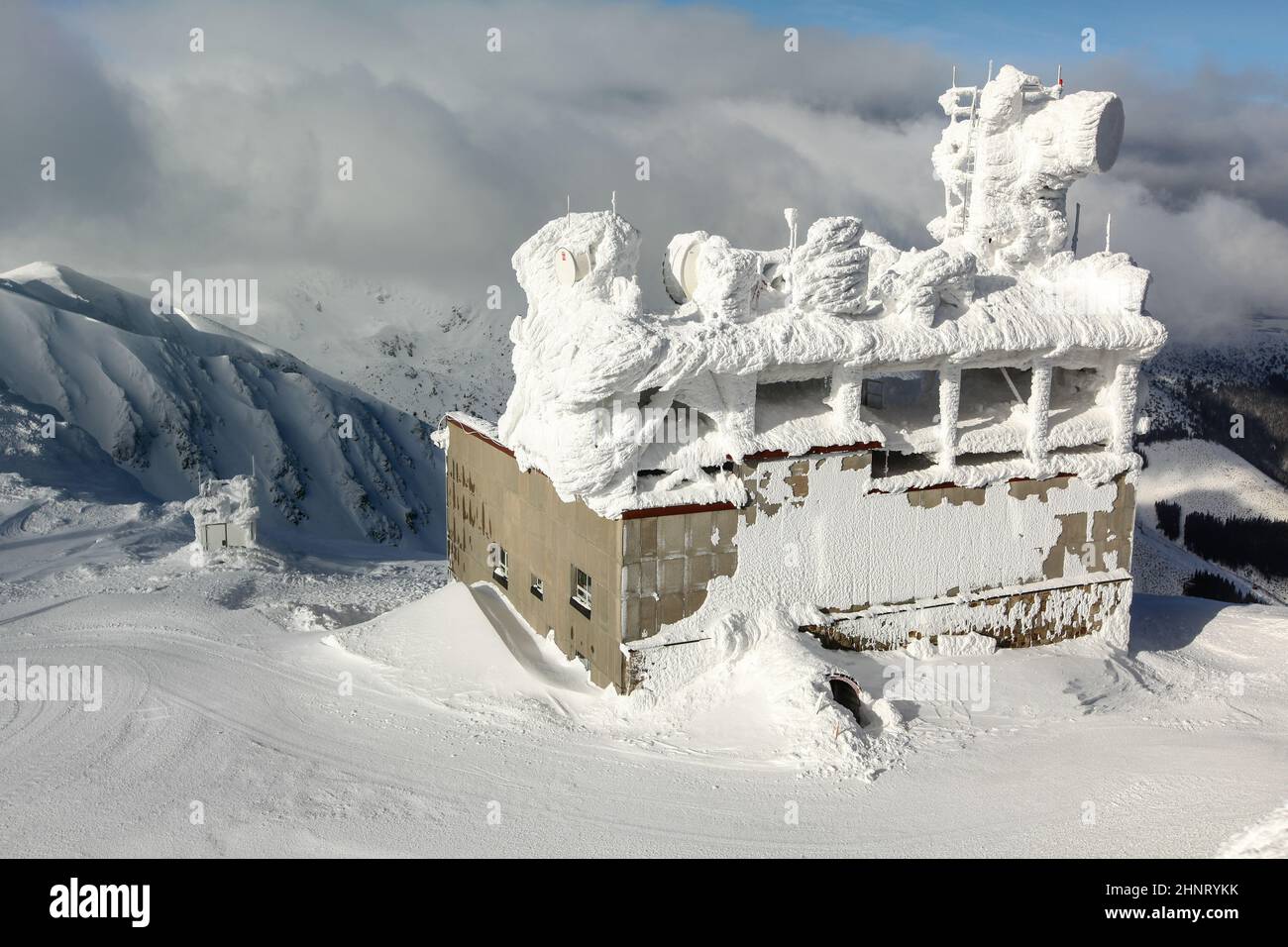 Jasna, Slowakei - 18. Januar 2018: Skilift-Gebäude, mit Antennen auf dem Dach, oben auf dem Chopok-Berg, komplett mit Schnee bedeckt. Starker Wind und Schnee sind im Winter auf den Gipfeln der Nizke Tatry verbreitet. Stockfoto
