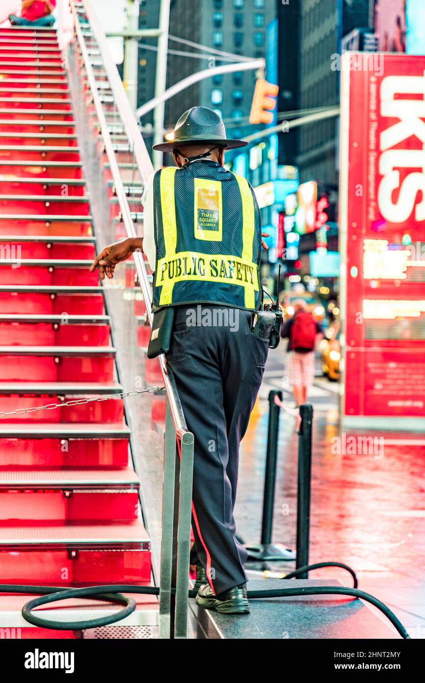 Am frühen Morgen beobachtet der Sicherheitsmann die Leute am Times Square Stockfoto