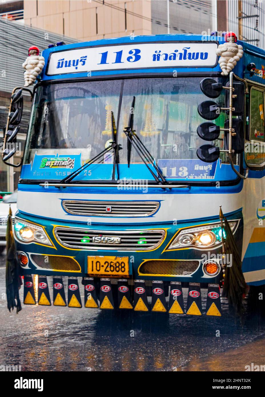 Typisch bunt blau dekoriert Bus in starkem Regen Bangkok Thailand. Stockfoto