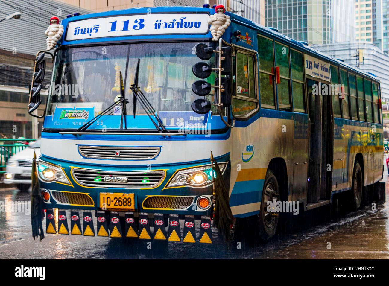 Typisch bunt blau dekoriert Bus in starkem Regen Bangkok Thailand. Stockfoto