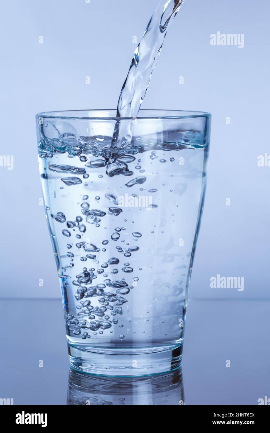 Gießen Sie Mineralwasser in ein Glas-Portrait-Format Stockfoto