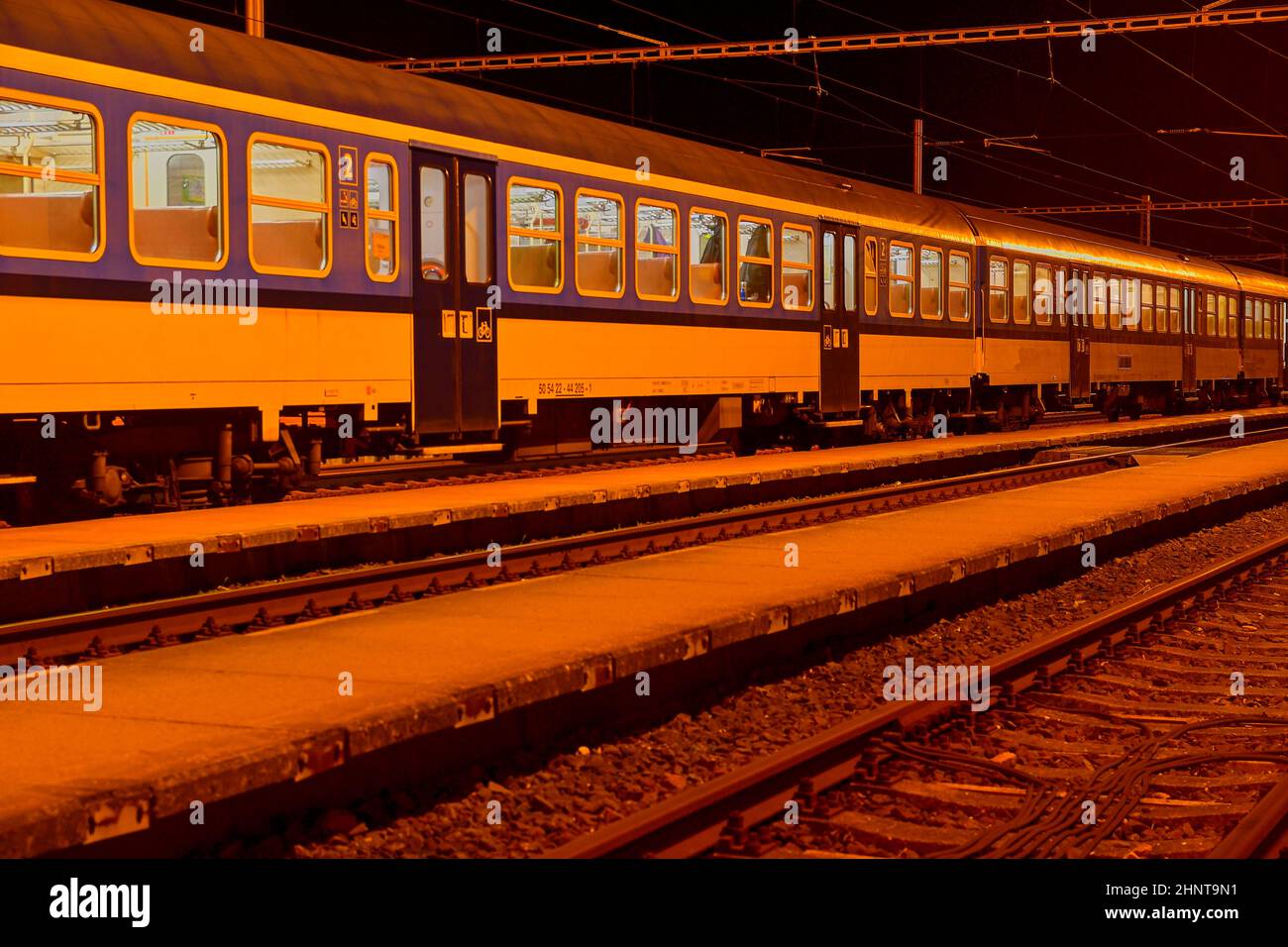 Weißen und Blauen Zug stehend an einem kleinen dachlosen Bahnhof bei Nacht in der Tschechischen Republik. Europäische Schulen Stockfoto