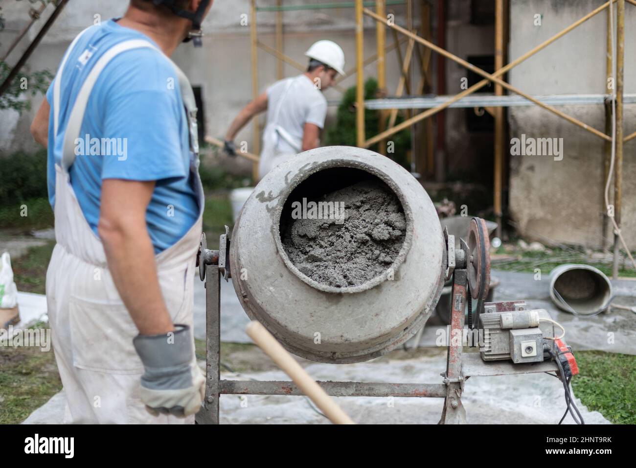 Labore-Arbeiter, der Betonzementmischer auf der Baustelle betreibt. Stockfoto