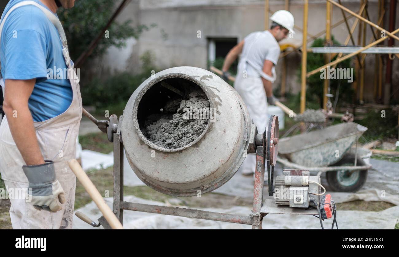Labore-Arbeiter, der Betonzementmischer auf der Baustelle betreibt. Stockfoto
