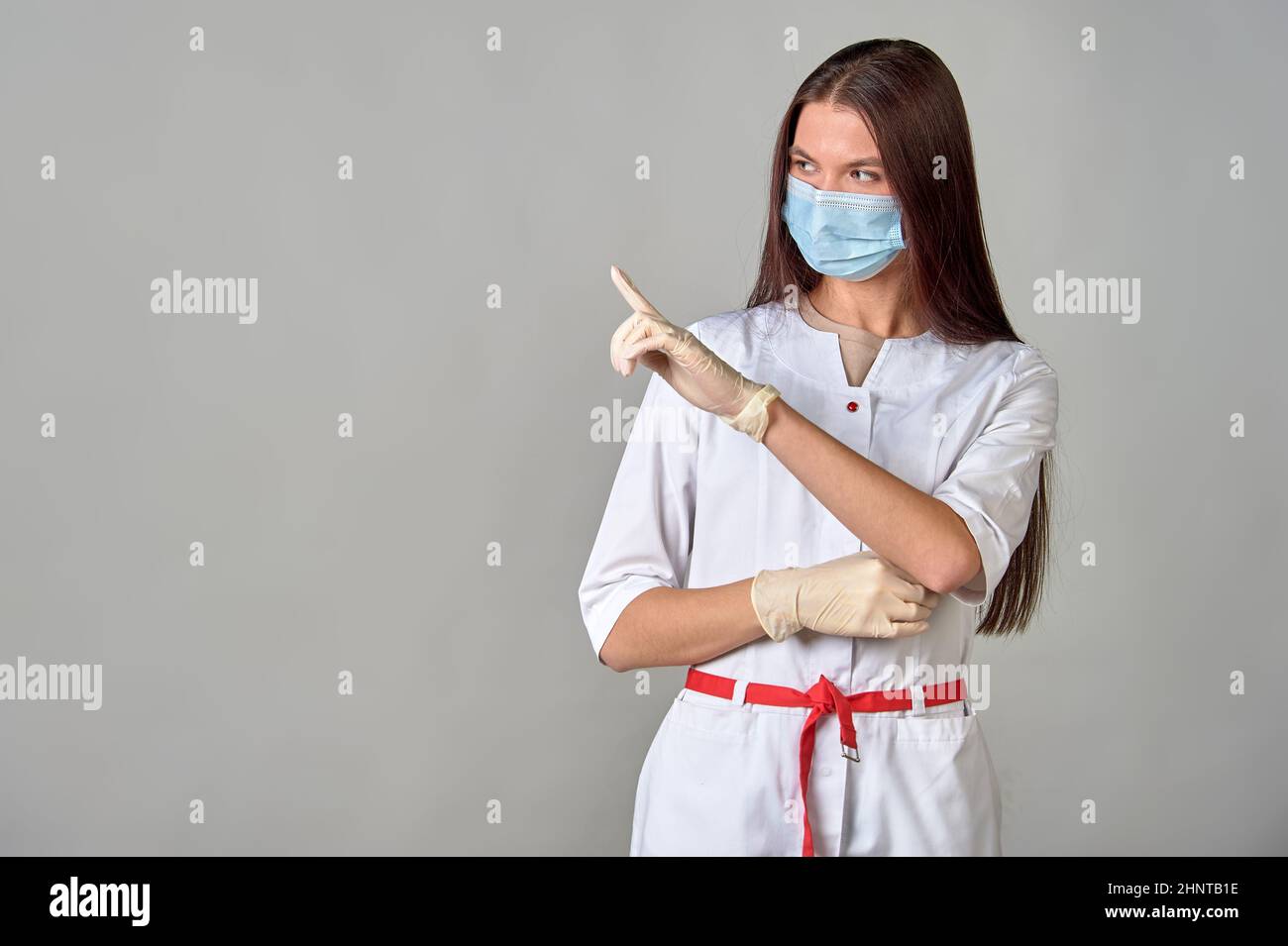 Eine Ärztin in einer medizinischen Maske zeigt auf einen leeren Platz, Kopierraum Stockfoto