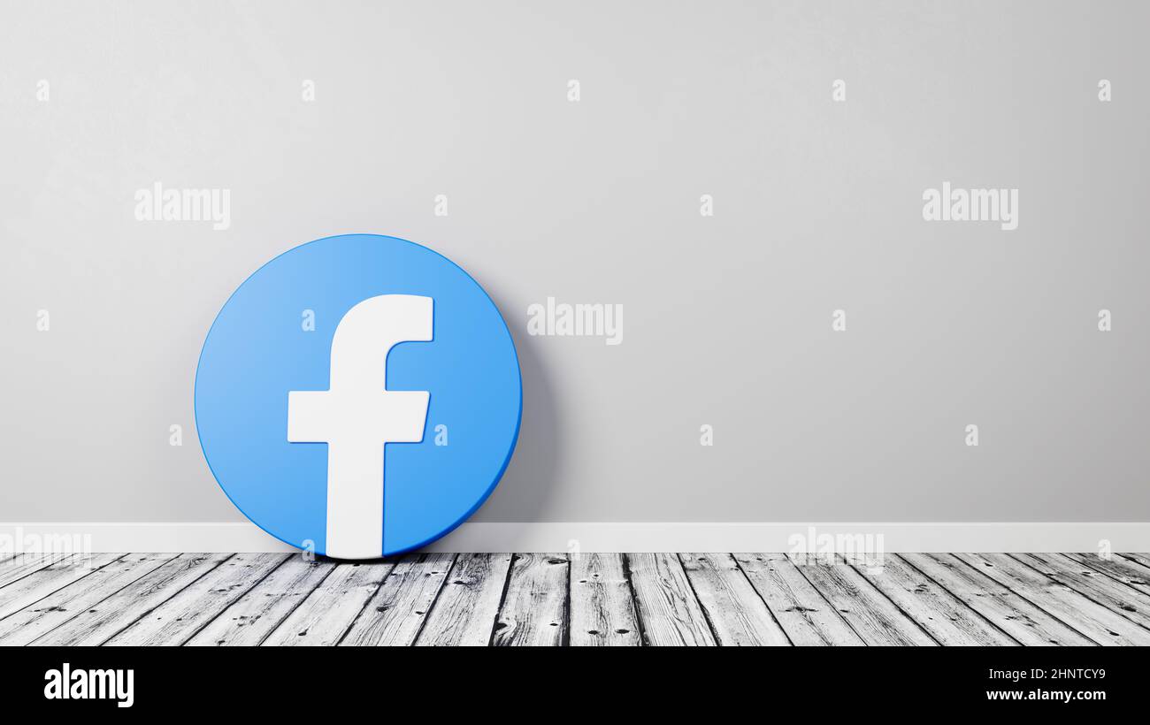 Facebook-Logo auf Holzboden gegen Wand Stockfoto