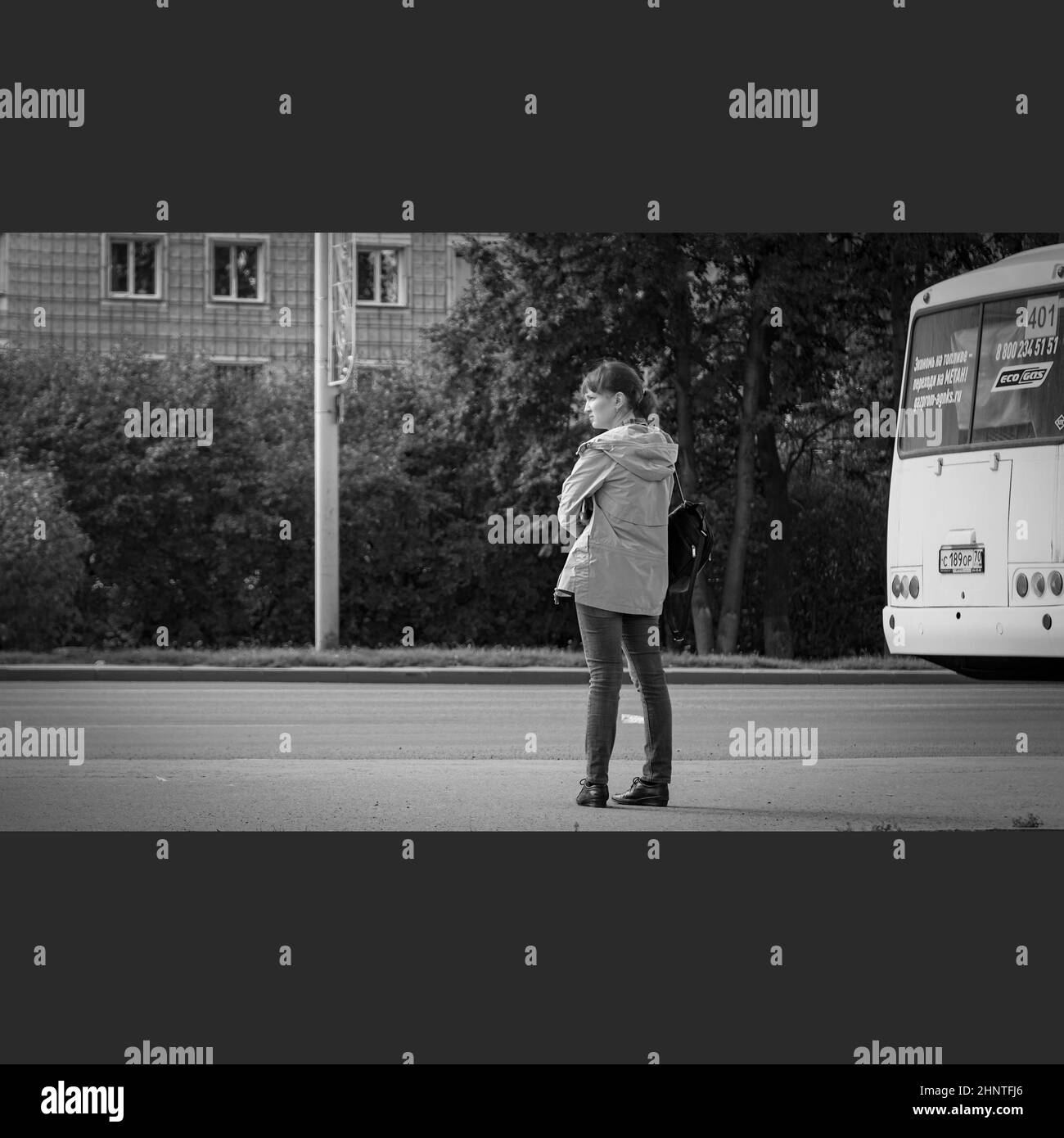 30th. August 2020, Russland, Tosmk, Frau wartet auf den Bus auf der Straße Stockfoto