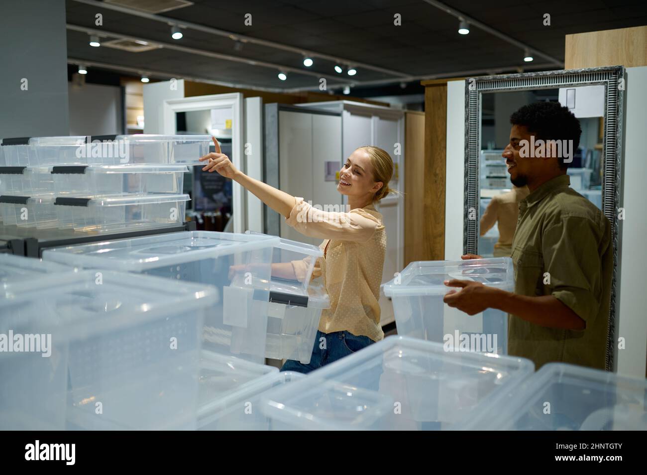 Frau, die im Geschäft Kunststoffbehälter auswählt Stockfoto