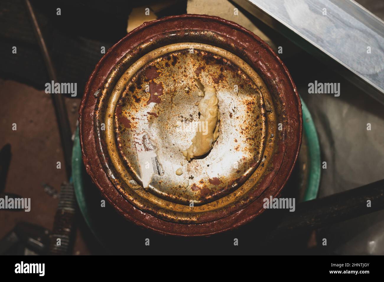 Rostiger Farbbecher, alter Eimer mit Acrylfarbe in einer Werkstatt Stockfoto