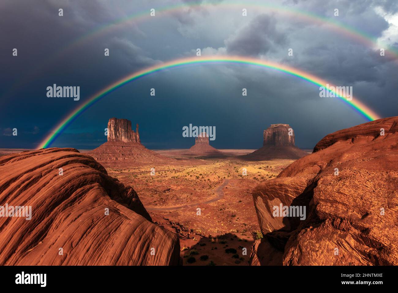 Monument Valley, Arizona mit einem lebendigen doppelten Regenbogen über den Fäustlingen Stockfoto