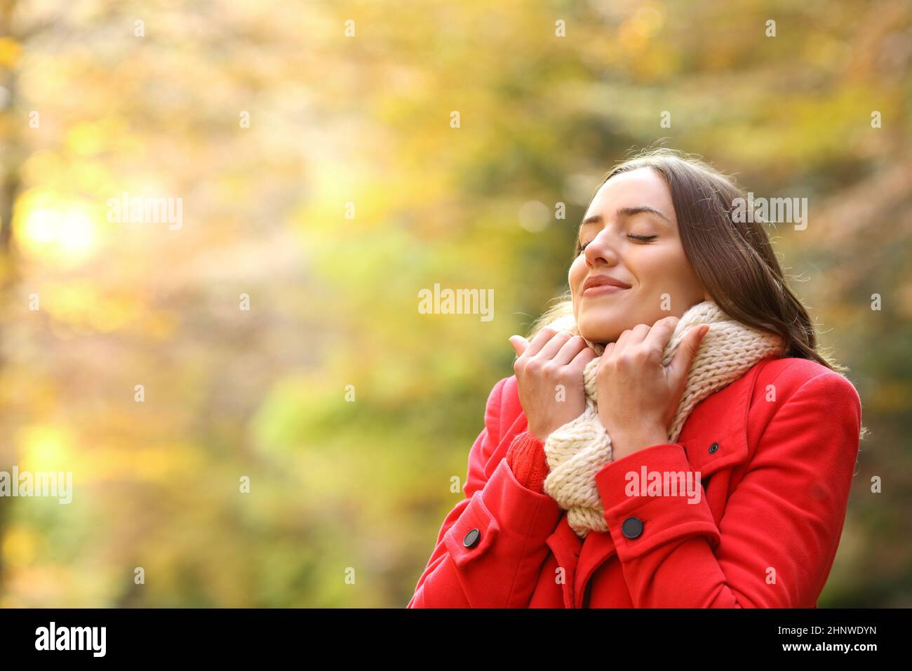 Fröhliche Frau in rot warm im Herbst in einem Park gekleidet Stockfoto