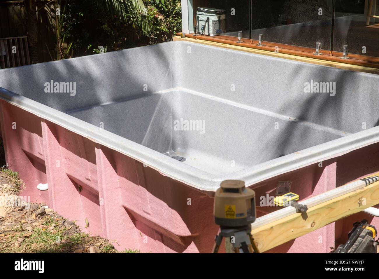 Fiberglas-Swimmingpool in Position im hinteren Garten eines Hauses in Sydney, in Erwartung der Anschlüsse und der endgültigen Installation, Sydney, NSW, Australien Stockfoto