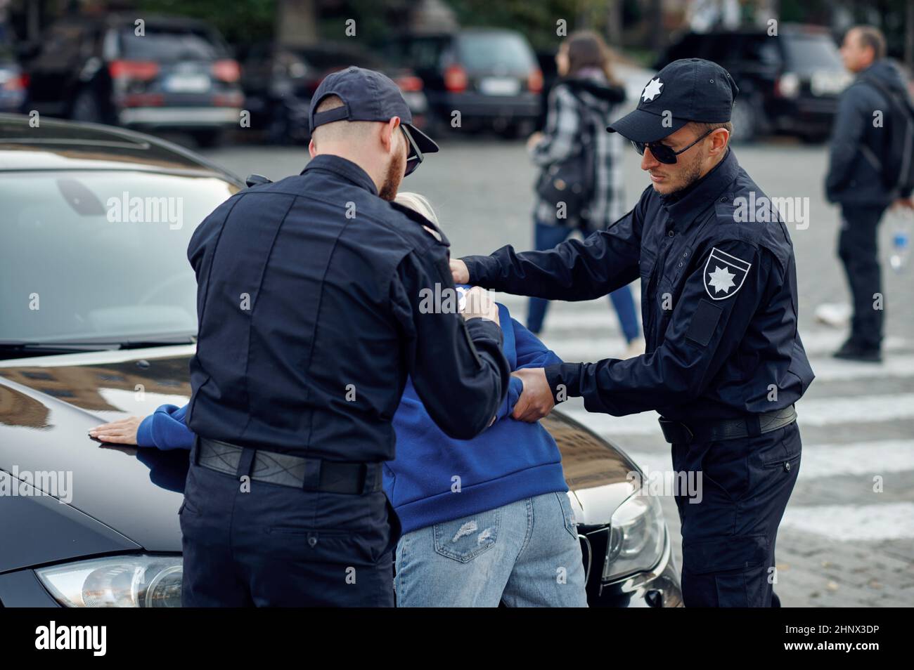 Zwei männliche Polizisten verhaften eine Fahrerin. Polizisten in Uniform schützen das Gesetz, die Registrierung einer Straftat. Bullen arbeiten auf der Stadtstraße, Ordnung und j Stockfoto