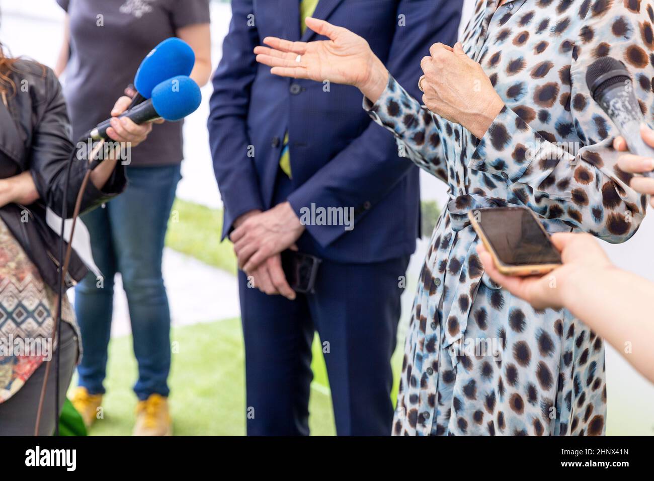 Reporter bei der Pressekonferenz halten Mikrofone machen Medieninterview mit Politikerin oder Geschäftsfrau Stockfoto