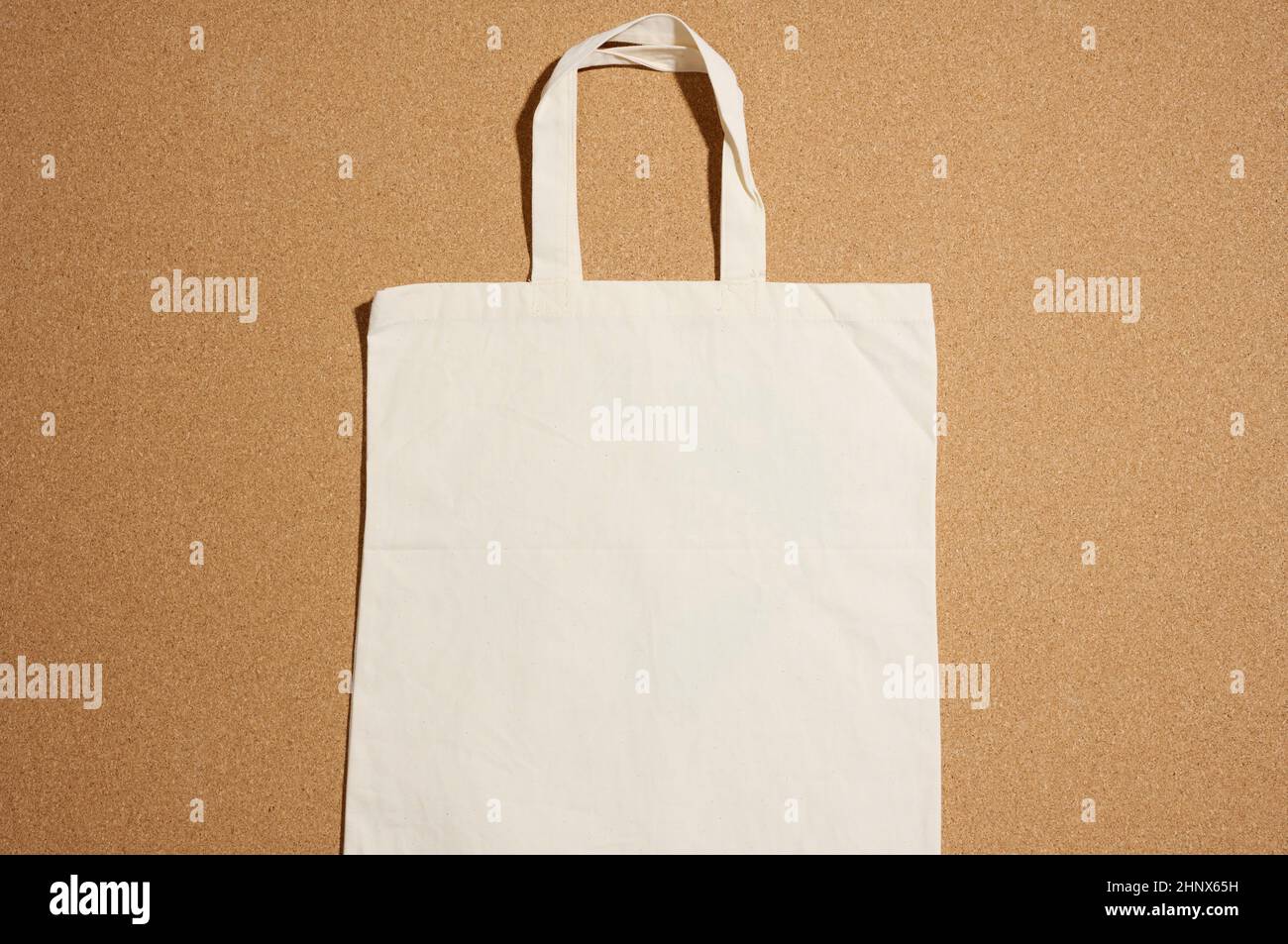 Leeres Leinen umweltfreundliche beige Leinwand-Tragetasche für Branding auf braunem Hintergrund. Durchsichtige wiederverwendbare Tasche für Lebensmittel, Nachbau. Flach liegend Stockfoto