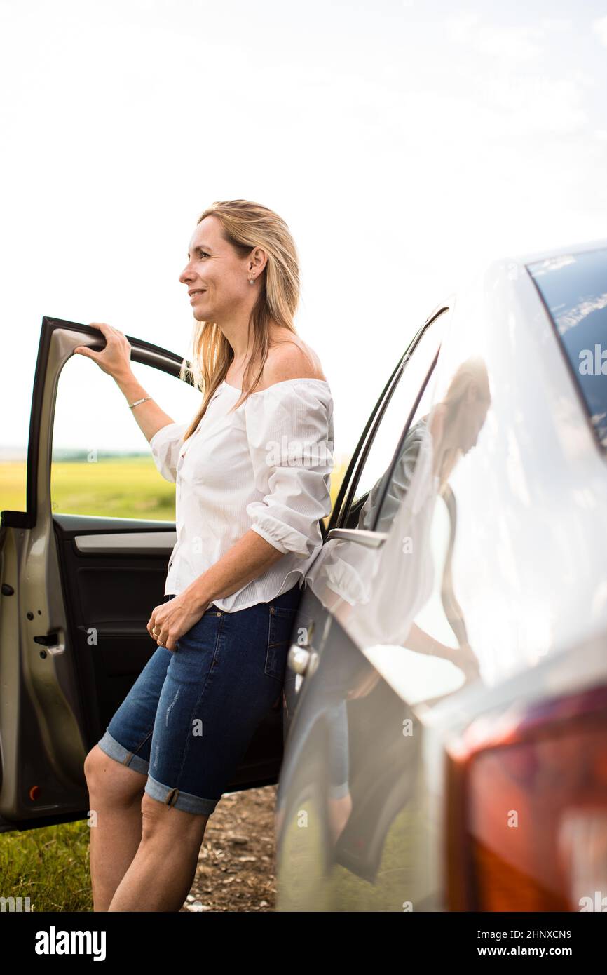 Hübsche Frau mittleren Alters am Steuer von ihr Auto Stockfoto
