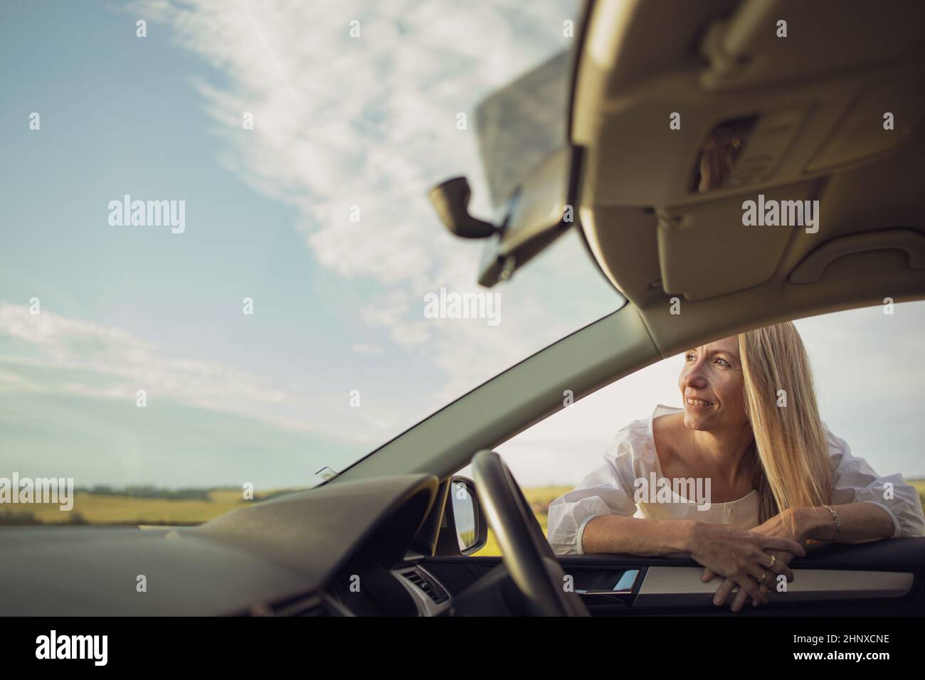 Hübsche Frau mittleren Alters am Steuer von ihr Auto Stockfoto