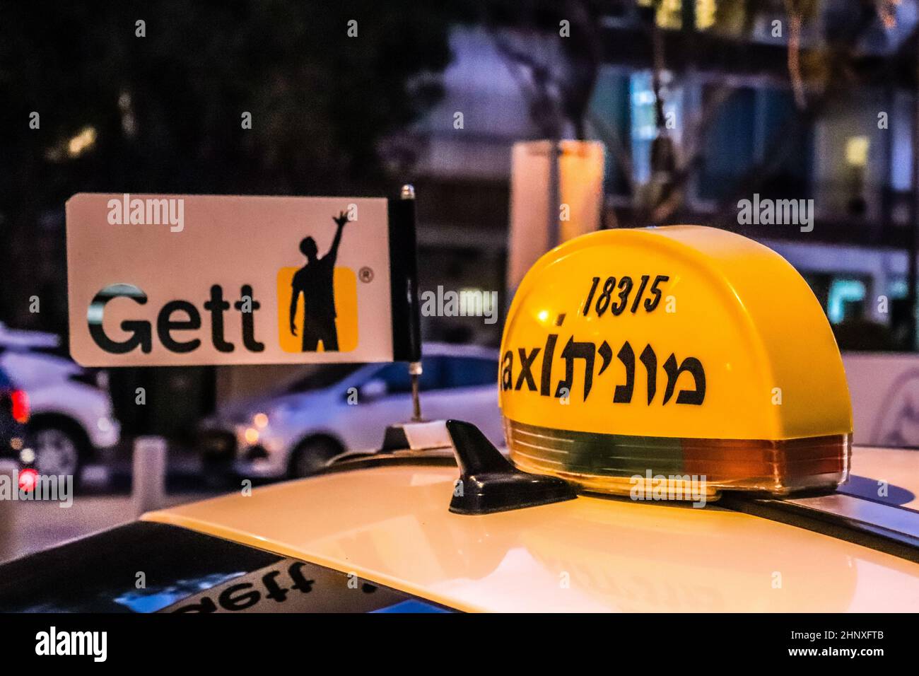 Tel Aviv, Israel - 15. Februar 2022 Taxi fährt in den Straßen von Tel Aviv während des Coronavirus-Ausbruchs trifft Israel, trägt eine Maske ist mandato Stockfoto