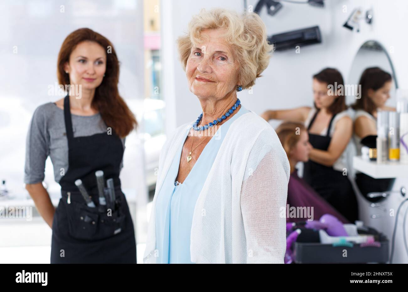 Lächelnde ältere Frau mit Friseur Stockfoto
