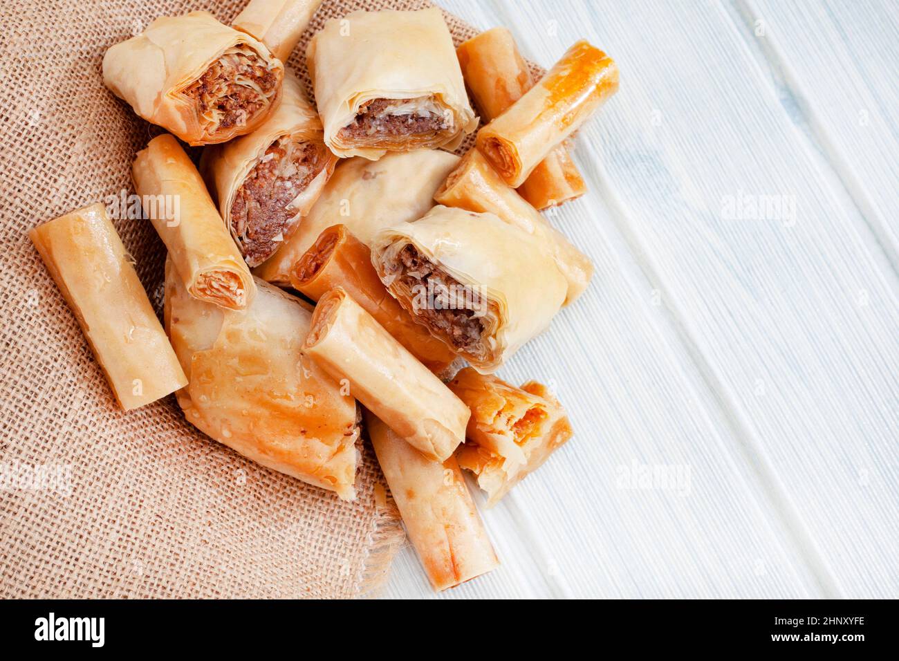 Kataifi ein griechisches Dessert, das von anderen östlichen Regionen des Balkans und des Mittleren Ostens geliebt wird. Spezielle dünne Teigstränge, gefüllt mit Nüssen und mit Sirup bedeckt. Stockfoto