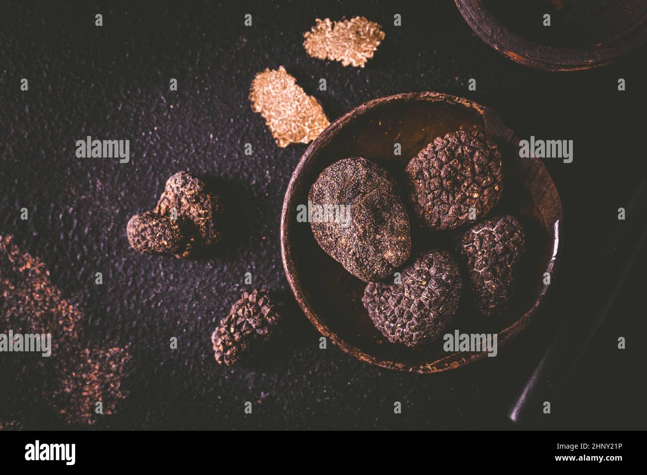Schwarzer Trüffel in Schüssel auf dunklem Hintergrund, kocht Delikatesse Stockfoto