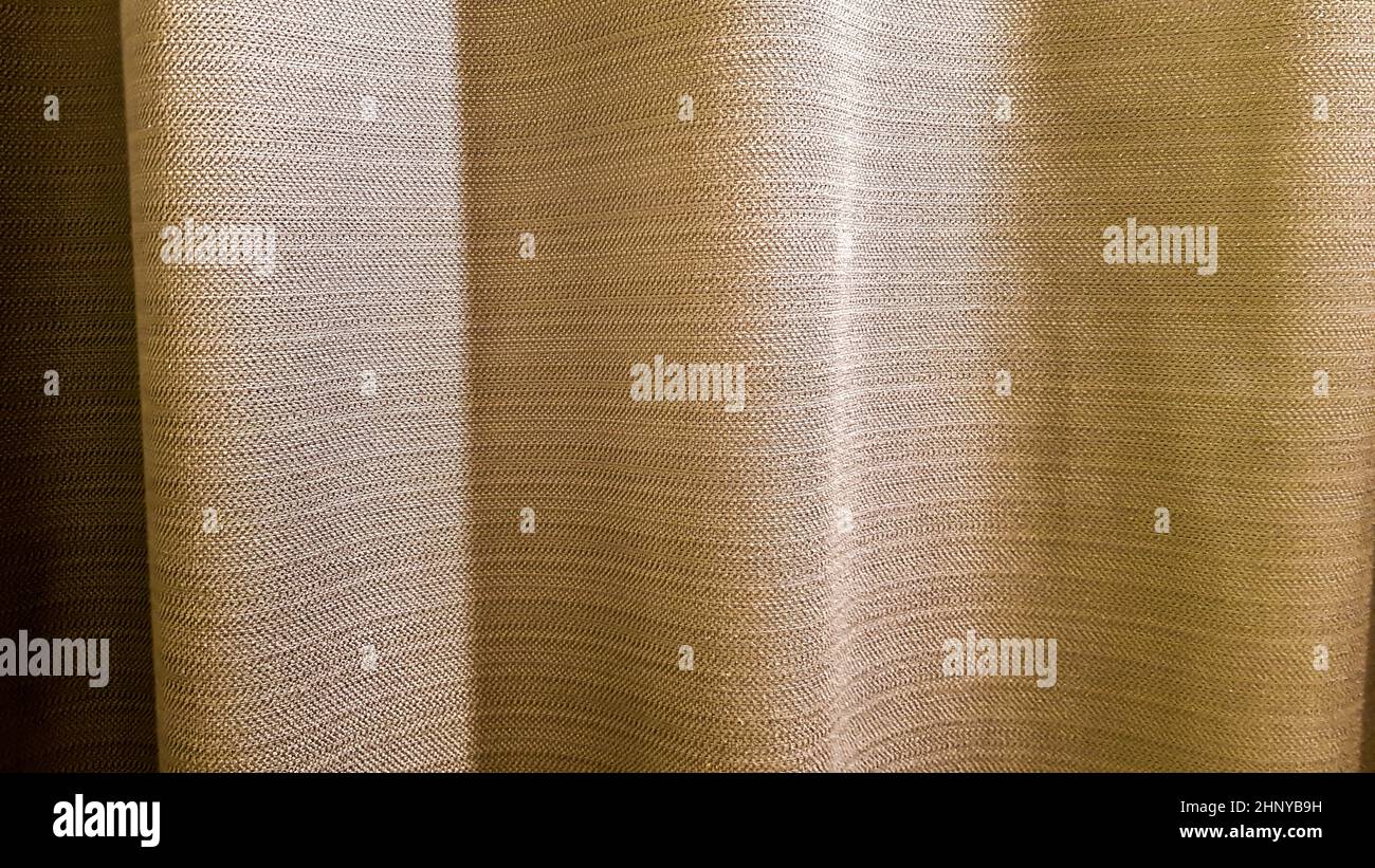 Braune Faltenware. Dick, angenehm zu berühren Vorhänge Nahaufnahme. Variante der Inneneinrichtung. Nähprodukt. Stockfoto