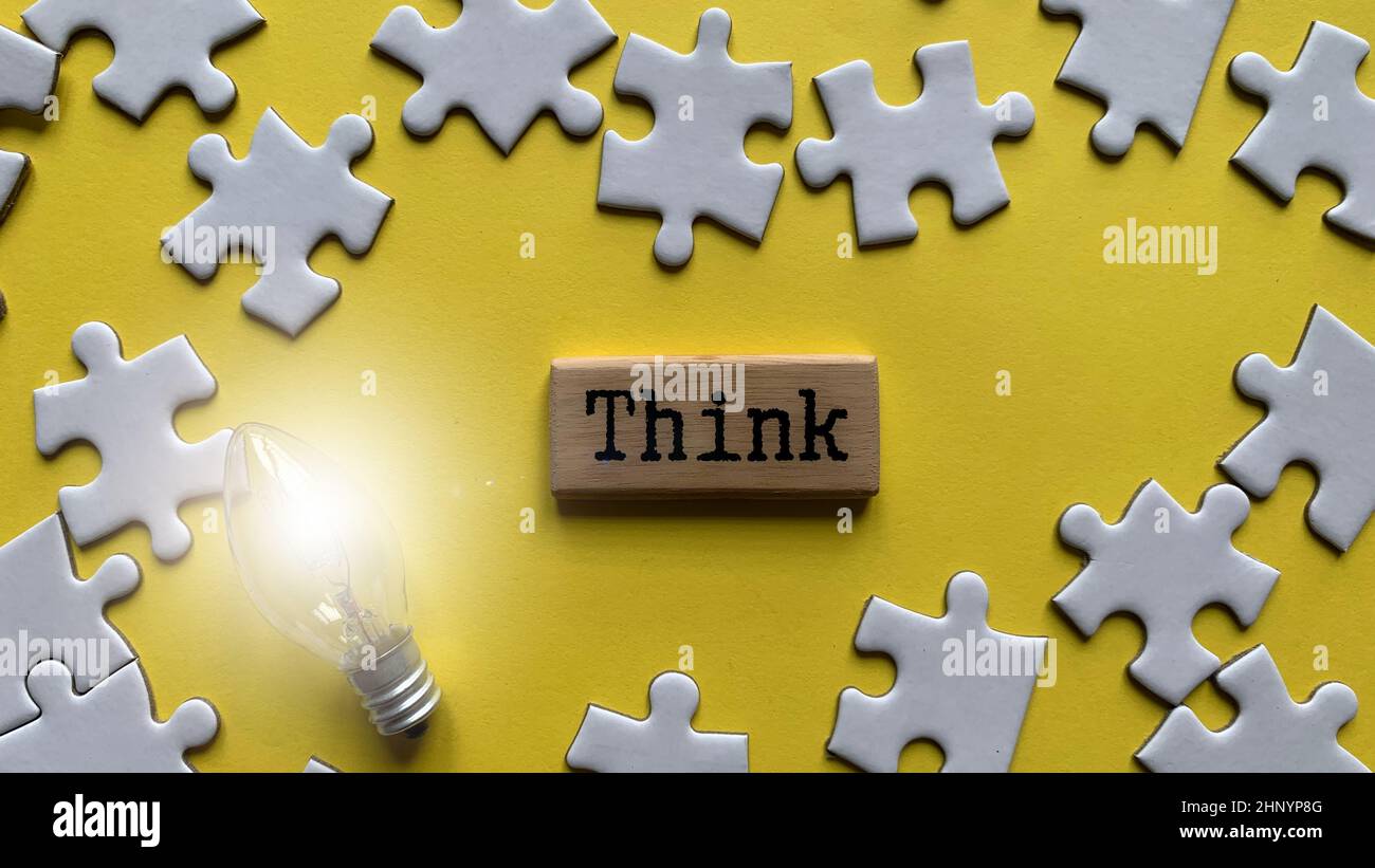 Draufsicht auf Wort - denken. Mit Puzzle und Glühbirne Hintergrund. Stockfoto