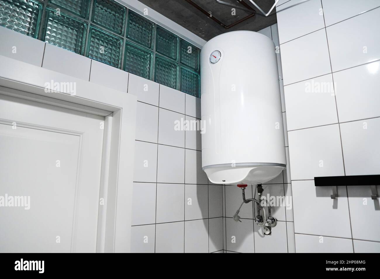 Haushaltsbudget-Warmwasserbereiter, der an der Wand im Kesselraum hängt. Moderner Gaskessel im Badezimmer. ? Ommon elektrische Speicher Wasser-Heizung. Hom Stockfoto