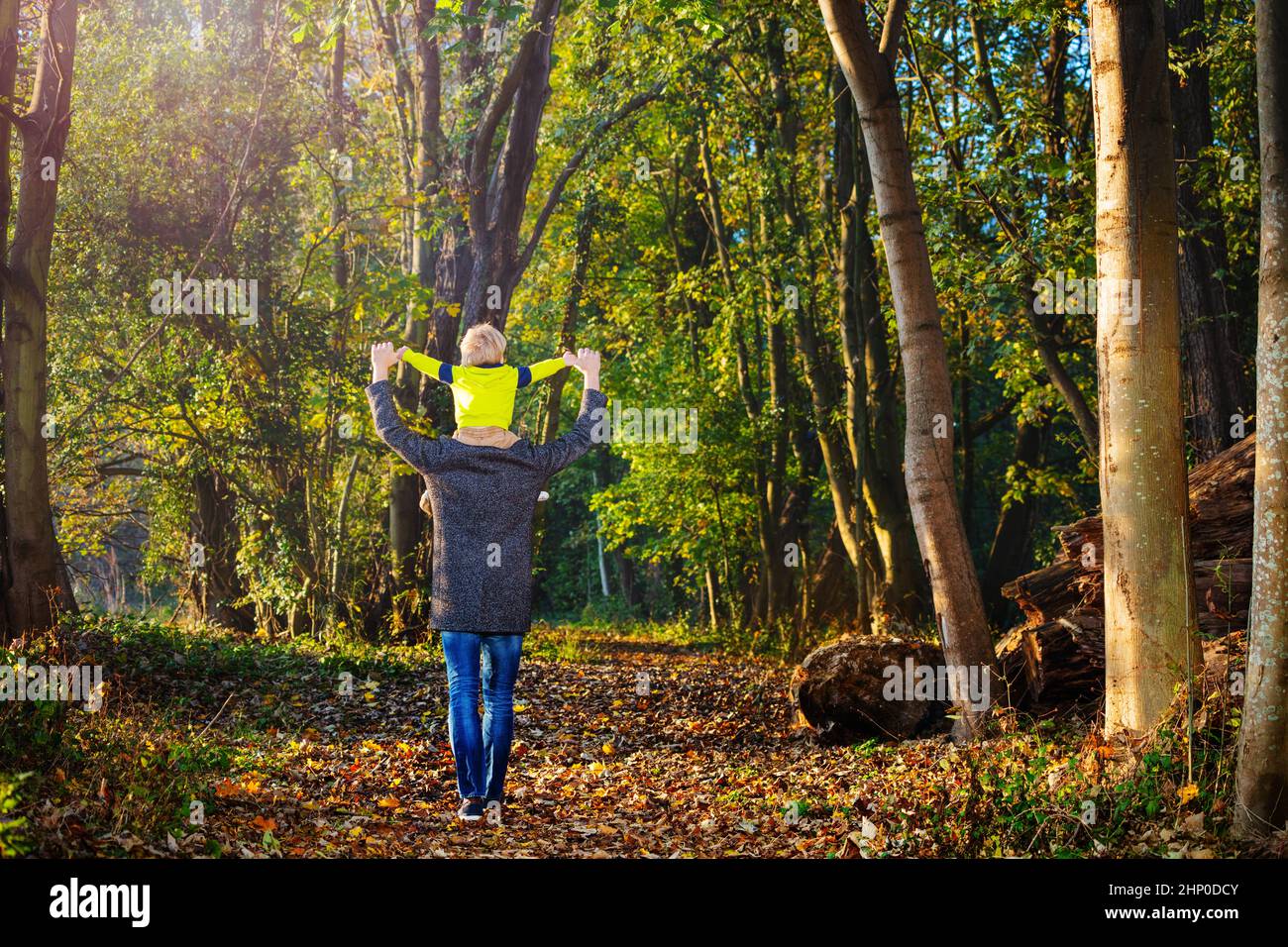 Vater geht mit seinem Sohn auf den Schultern im Wald Stockfoto