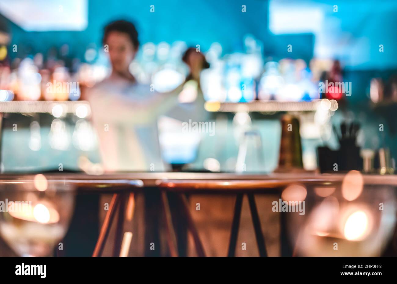 Verschwommener, unverschwommener Barkeeper, der zur Happy Hour in der Reakeasy Retro-Bar einen Cocktail schüttelt - Mixologiekonzept mit verschwommenem Barkeeper bei der Arbeit - Teal und Ora Stockfoto